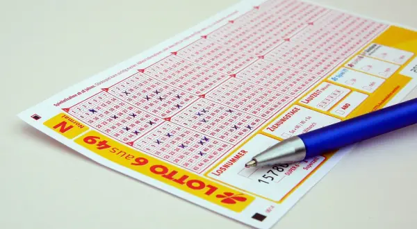 Kupon do gry Lotto z zaznaczonymi liczbami i długopisem. Zastanawiasz się, jak zablokować konto na stronie Lotto samowykluczenie na stałe?