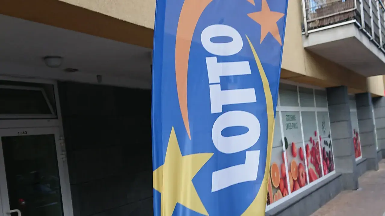 Niebieska flaga z logo LOTTO i gwiazdami. Szukasz rankingu zdrapek lotto z największym prawdopodobieństwem trafienia?