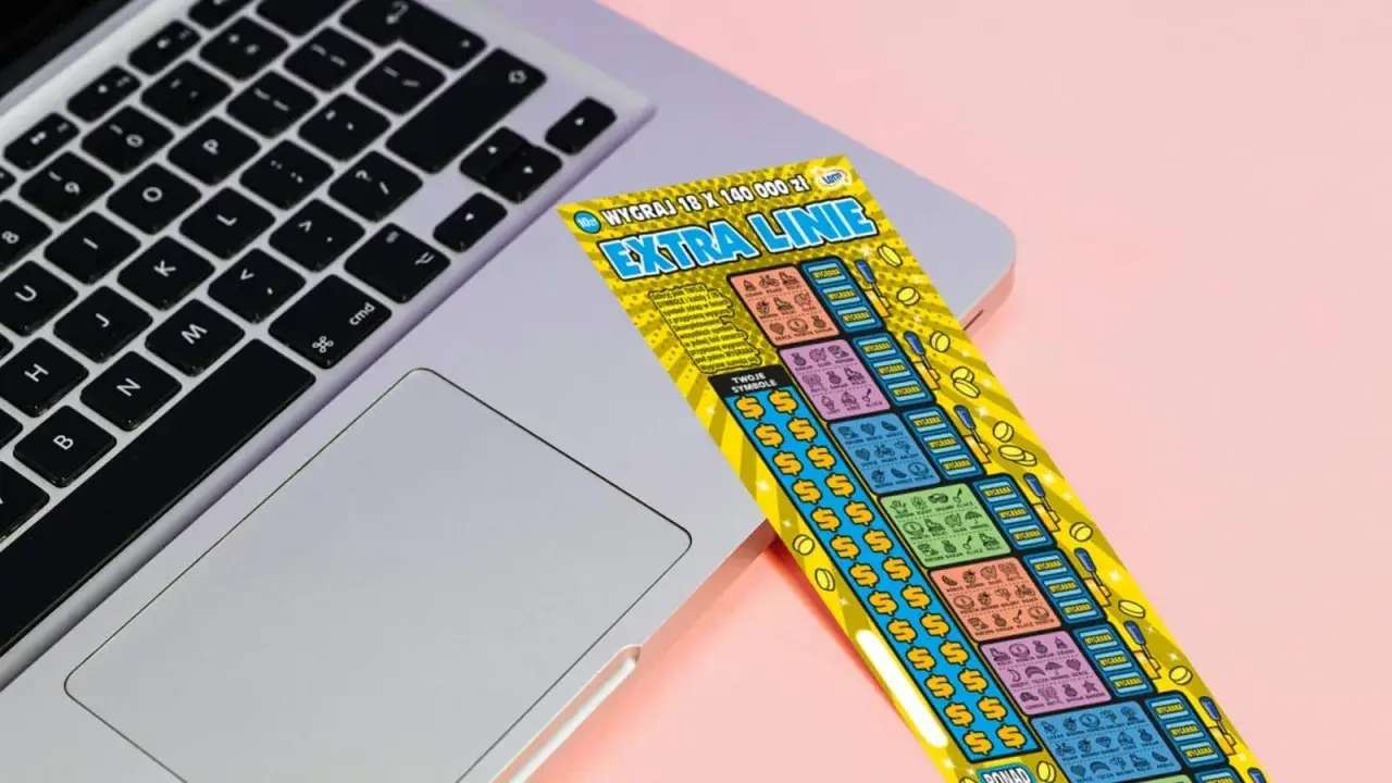 Zdrapka "Extra Linie" leży na laptopie. Czy uda się znaleźć wygrywające symbole i dodatkowe linie?