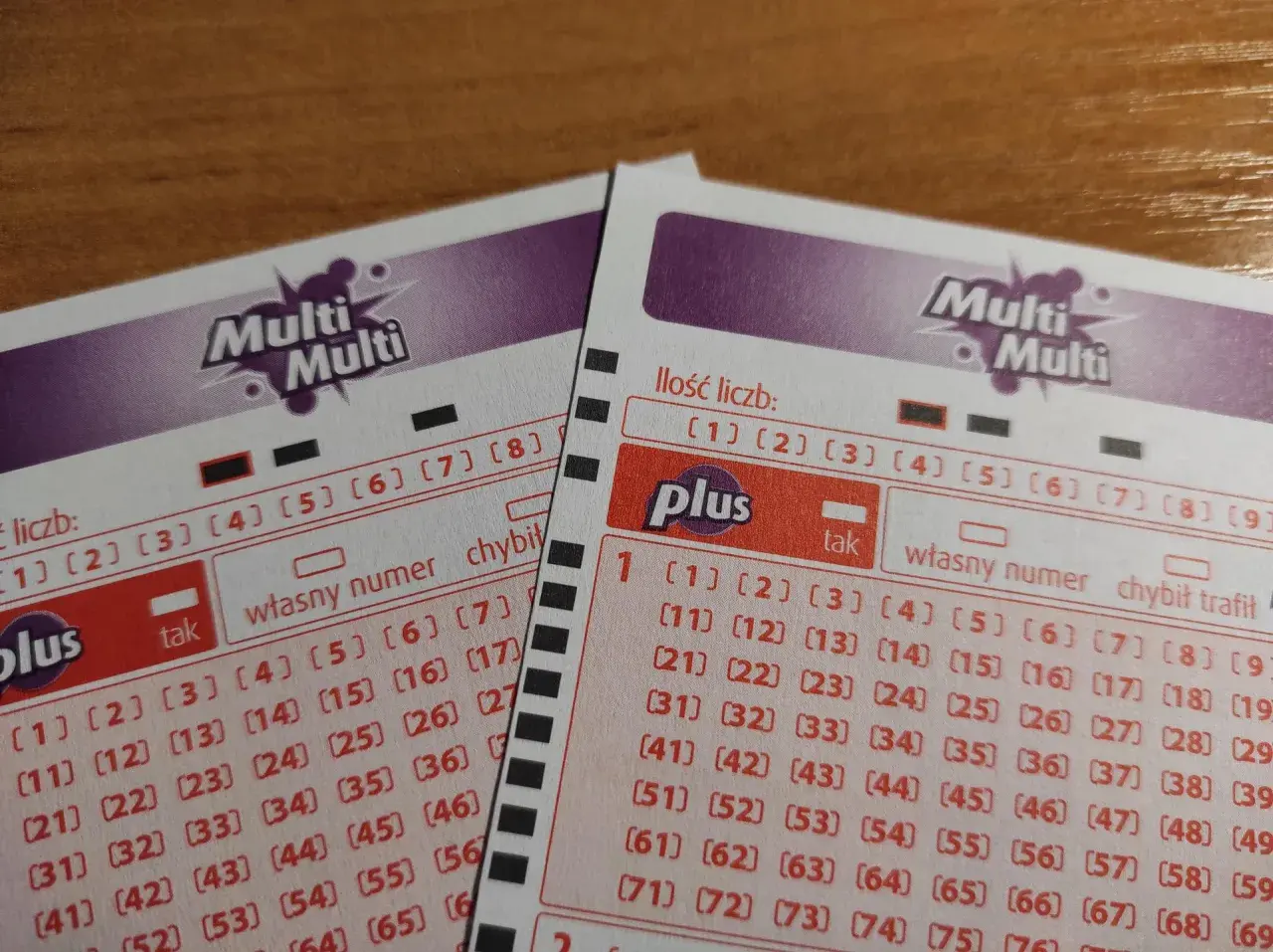 Dwie karty do gry Multi Multi Plus z polami do zaznaczania liczb. Widoczna tabela wygranych w Multi Multi Plus.