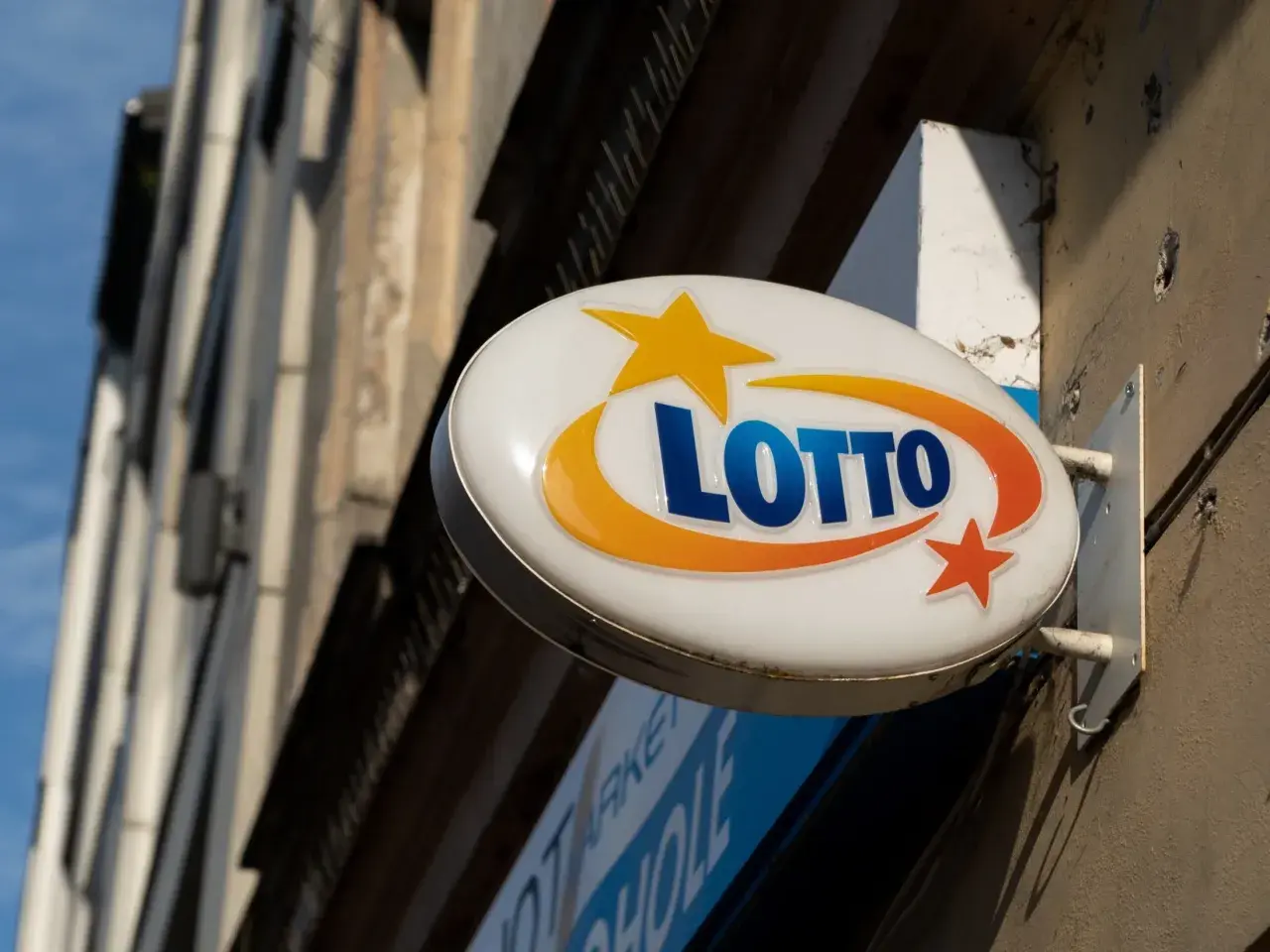 Znak Lotto z gwiazdkami i łukami, przypominający o tym, kiedy najbliższe losowanie lotto.