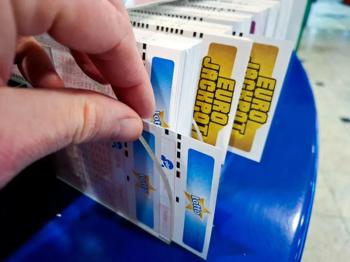 Dłoń wybiera kupony Lotto, marząc o multipasko wysokich wygranych.