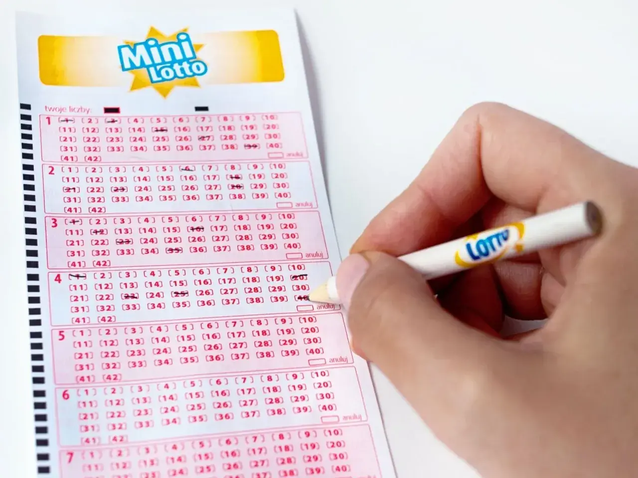 Ręka zaznacza liczby na kuponie Mini Lotto. Kto wie, może to właśnie te liczby przyniosą wygraną!