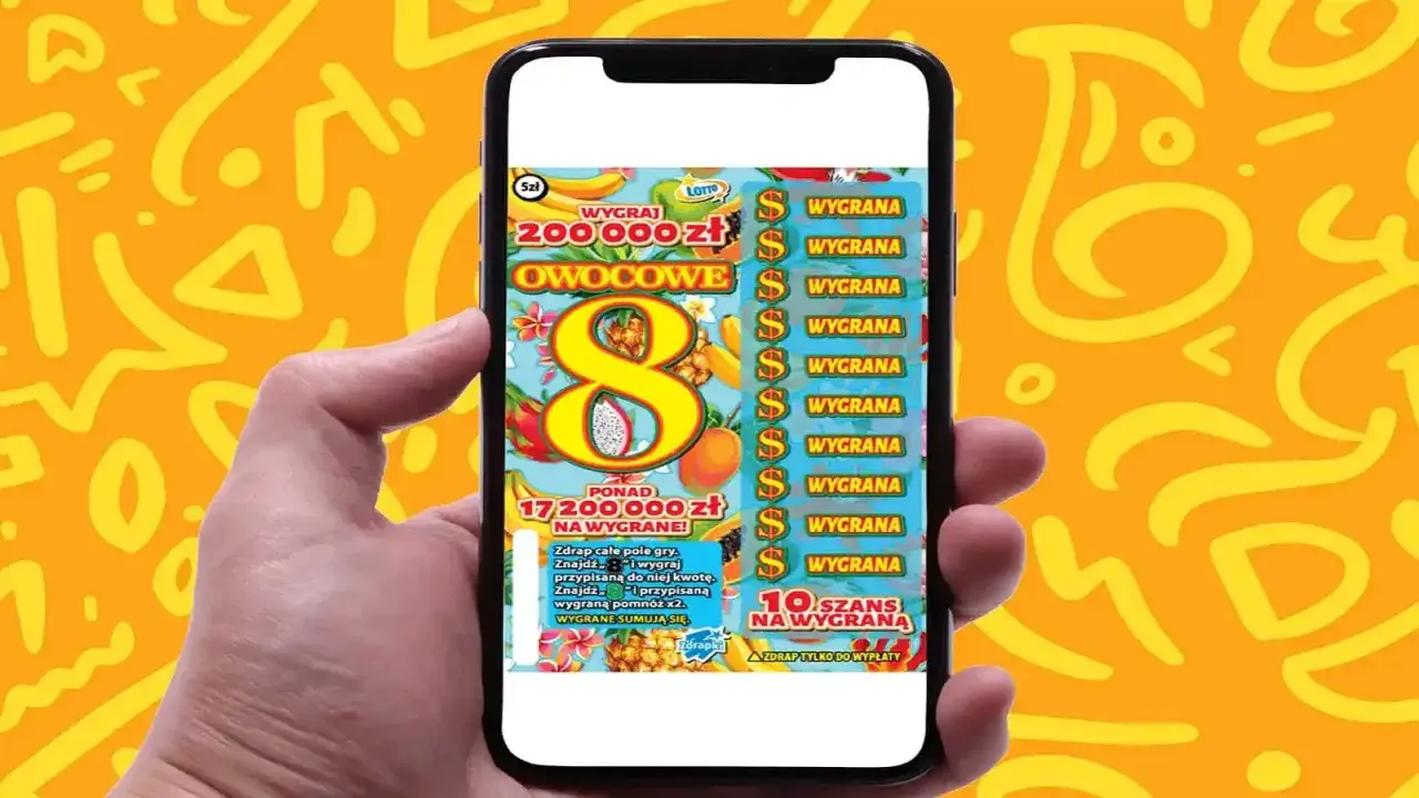 Ręka trzyma smartfon z grą "Owocowa eksplozja zdrapka". Na ekranie widać tropikalne owoce i symbol ósemki.
