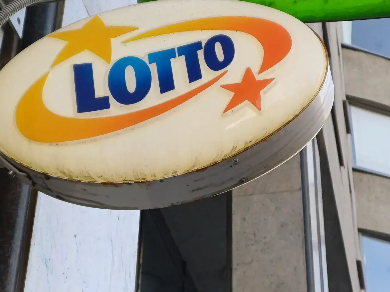 Oświetlony znak LOTTO z pomarańczowymi i żółtymi gwiazdami, symbolizujący szansę na wygraną w mega lotto pl.