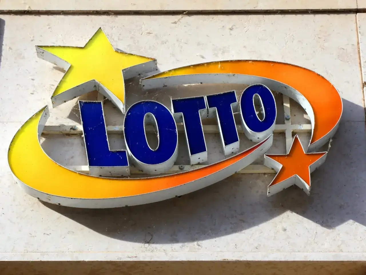 Neonowy napis LOTTO z gwiazdkami. Gdzie matematyka daje większe prawdopodobieństwo wygranej: eurojackpot vs lotto.