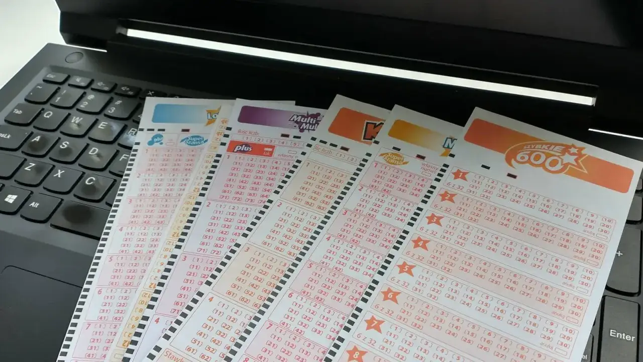Systemy do gier liczbowych na laptopie. Czy można przewidzieć wyniki loterii? Kupony lotto leżą na klawiaturze.