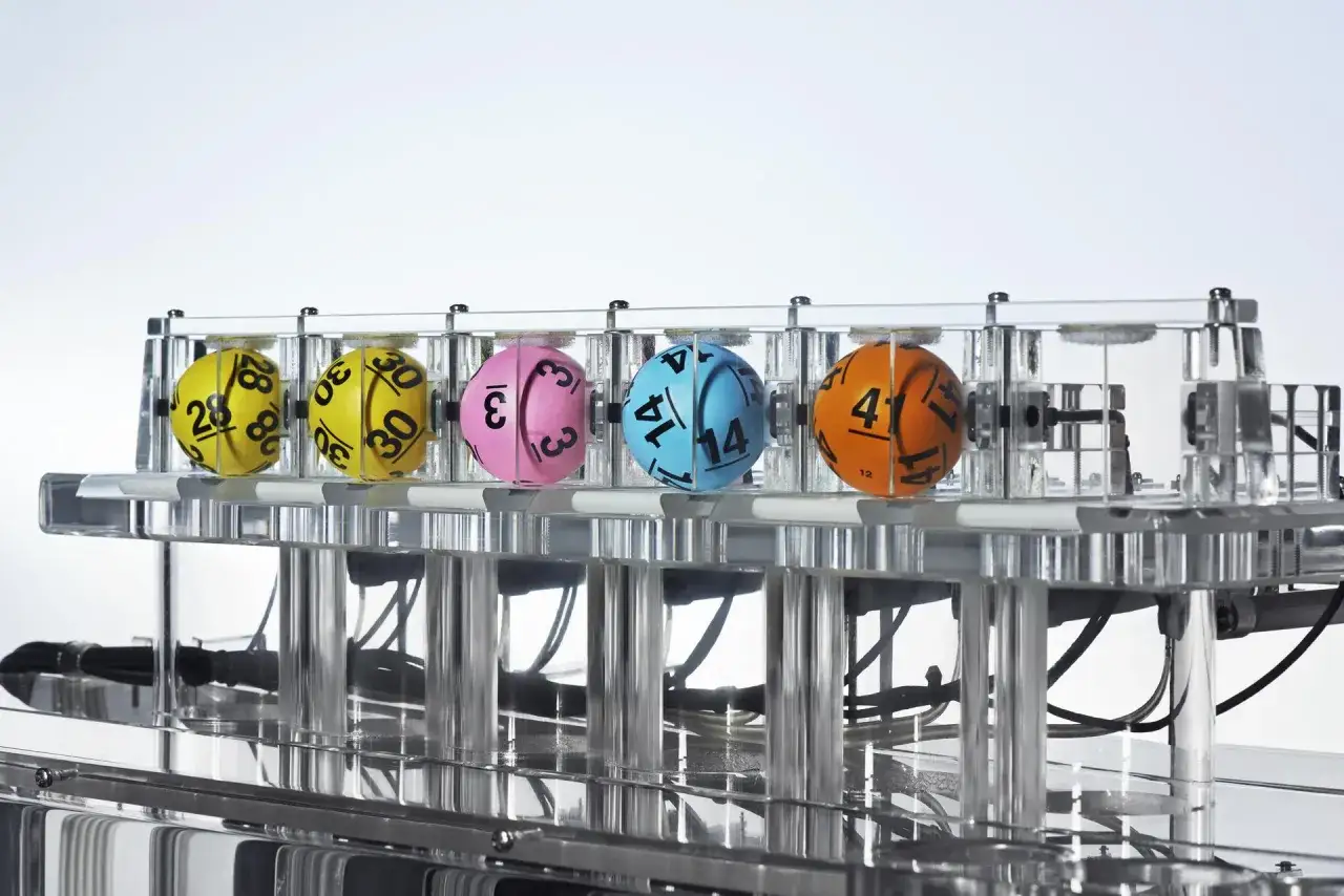 Losowanie Lotto odbywa się we wtorki, czwartki i soboty. Na zdjęciu kolorowe kule z numerami w maszynie losującej.